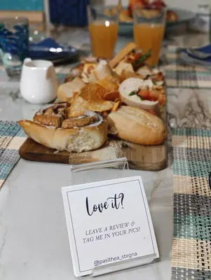 a table with a plate of bread and a sign at Pasithea Luxury house in Archangelos