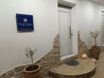 a door with two potted trees in a room at Pasithea Luxury house in Archangelos