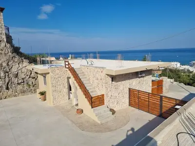 a stone building with a staircase and a view of the ocean at Pasithea Luxury house in Archangelos