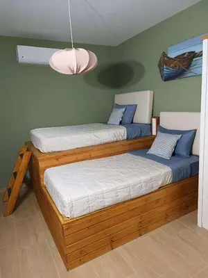 two twin beds in a room with a lamp at Pasithea Luxury house in Archangelos
