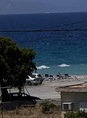 a view of the ocean with chairs and umbrellas at ODYSSEA Top View & Hot Jacuzzi Front Beach in Kremasti