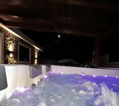 a jacuzzi tub in a house at night at ODYSSEA Top View & Hot Jacuzzi Front Beach in Kremasti