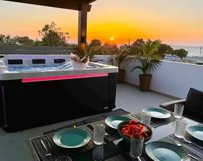a table with plates of food on a patio at ODYSSEA Top View & Hot Jacuzzi Front Beach in Kremasti