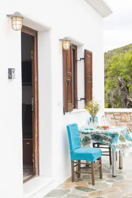 a table and chairs on a patio with a window at Maria's Traditional Villa in Asklipiḯon