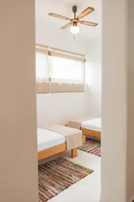 two beds in a room with a ceiling fan at Maria's Traditional Villa in Asklipiḯon