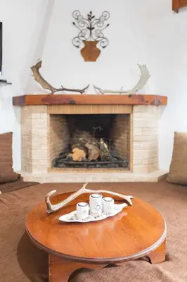 a coffee table with two cups on it in front of a fireplace at Maria's Traditional Villa in Asklipiḯon