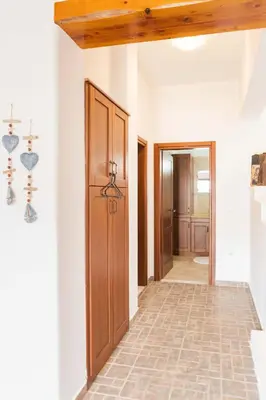 a hallway with a wooden door and a tile floor at Maria's Traditional Villa in Asklipiḯon