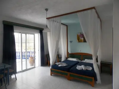 a bedroom with a bed and a large window at Annas Studios in Livadia