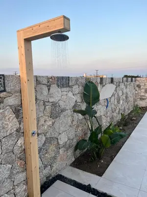 a stone wall with a shower in front of it at Cora May Central Villa with private pool 200m to the beach in Faliraki