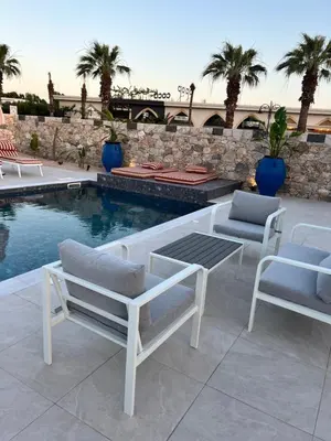 a patio with two chairs and a table and a pool at Cora May Central Villa with private pool 200m to the beach in Faliraki