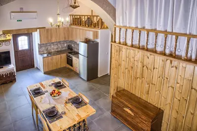 a kitchen with a wooden table and a refrigerator at Stone Arch in Malona Village