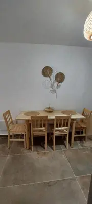 a dining room table and chairs with a white wall at Lindos Alley in Líndos