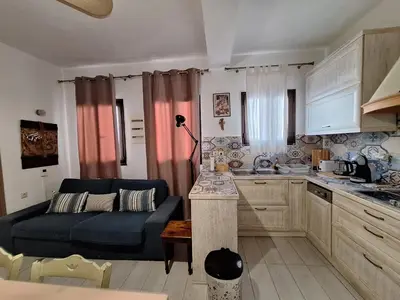 a kitchen and a living room with a couch and a table at Lindos Alley in Líndos
