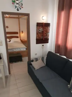 a living room with a couch and a mirror at Lindos Alley in Líndos