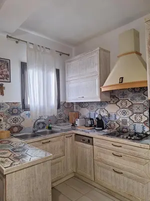 a kitchen with wooden cabinets and a stove top oven at Lindos Alley in Líndos