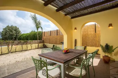 an outdoor patio with a wooden table and chairs at Villa Asteria in Gennadi