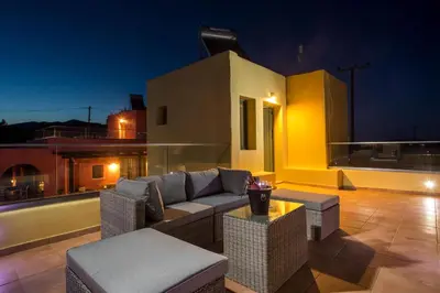 a living room with a couch and chairs on a patio at Villa Asteria in Gennadi