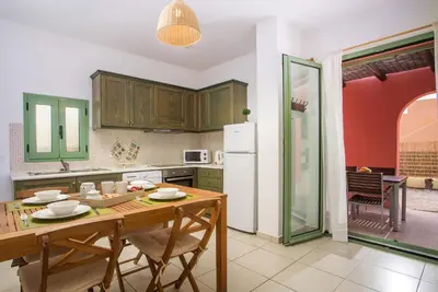 a kitchen with a wooden table and a white refrigerator at Villa Selene in Gennadi