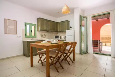 a kitchen with a wooden table and chairs in it at Villa Selene in Gennadi