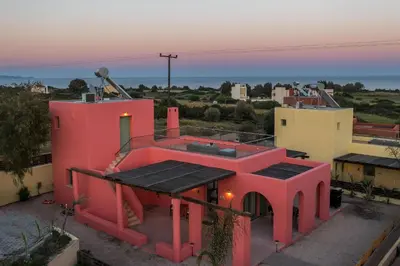 a pink house with the sunset in the background at Villa Selene in Gennadi