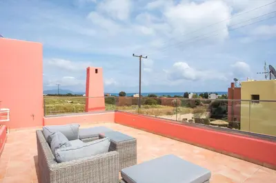 a balcony with a couch and a view of the ocean at Villa Selene in Gennadi