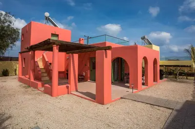 a red building with an archway in a yard at Villa Selene in Gennadi
