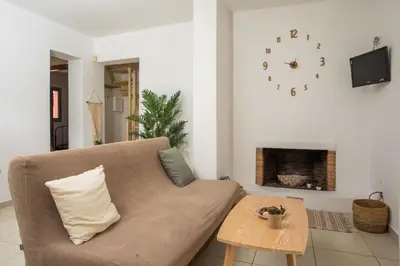 a living room with a couch and a clock on the wall at Villa Selene in Gennadi
