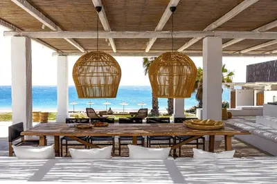 a patio with a table and chairs and the ocean at Beachfront Villa Crystalia in Lachania