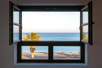 a window with a view of the beach at Beachfront Villa Crystalia in Lachania