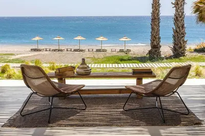 a table and two chairs with a table and a beach at Beachfront Villa Crystalia in Lachania