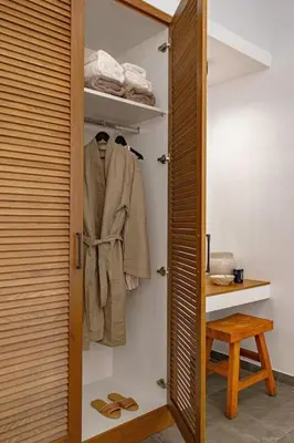 a closet with a door open with a coat and shoes at Beachfront Villa Crystalia in Lachania