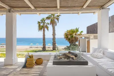 a patio with a table and a view of the beach at Beachfront Villa Crystalia in Lachania