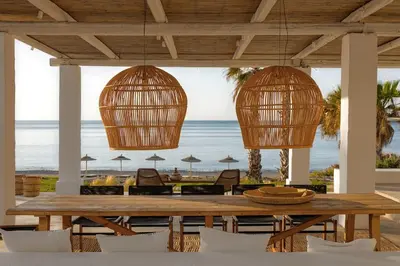 a dining room with a table and chairs and the beach at Beachfront Villa Crystalia in Lachania