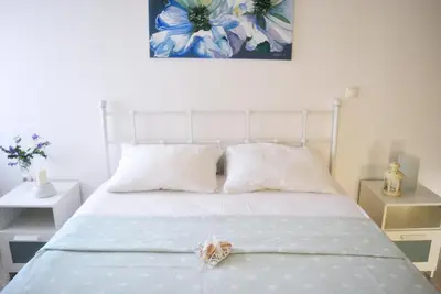 a bedroom with a white bed with a teddy bear on it at Apartment Margerita in Asgourou