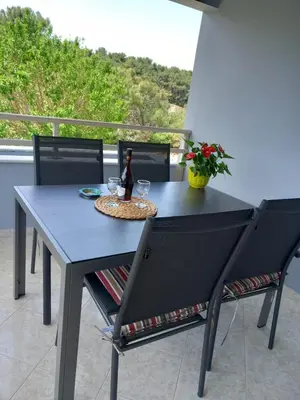 a blue table with two chairs and a bottle of wine at Apartment Margerita in Asgourou