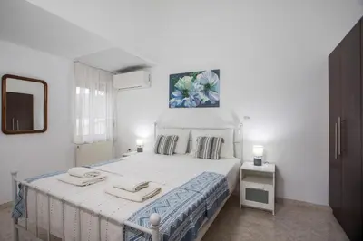 a white bedroom with a bed with two towels on it at Apartment Margerita in Asgourou