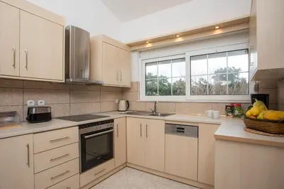 a kitchen with white cabinets and a sink and a window at Apartment Margerita in Asgourou