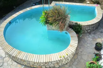an overhead view of a large blue swimming pool with plants at Apartment Margerita in Asgourou