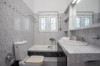 a bathroom with a toilet and a sink and a tub at Apartment Margerita in Asgourou