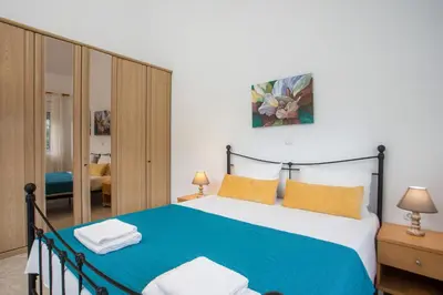 a bedroom with a bed with blue sheets and yellow pillows at Apartment Margerita in Asgourou