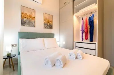 a bedroom with a white bed with towels on it at Nikargy Luxury Apartments in Koskinou