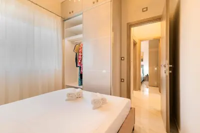 a bedroom with a white bed and a closet at Nikargy Luxury Apartments in Koskinou