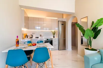 a kitchen with blue chairs and a table with food on it at Nikargy Luxury Apartments in Koskinou