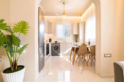 a kitchen and dining room with a table and a plant at Nikargy Luxury Apartments in Koskinou