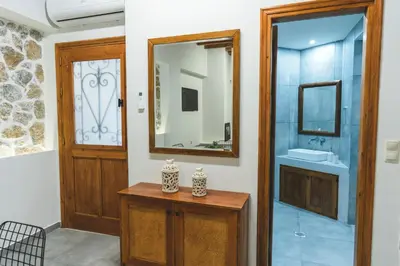 a bathroom with a sink and a mirror at Aesthisis Sensational Accommodation Archangelos in Archangelos