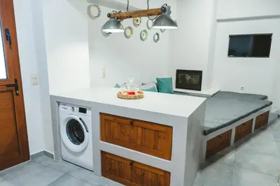 a kitchen with a washing machine in a room at Aesthisis Sensational Accommodation Archangelos in Archangelos