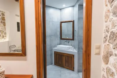 a bathroom with a sink and a mirror at Aesthisis Sensational Accommodation Archangelos in Archangelos