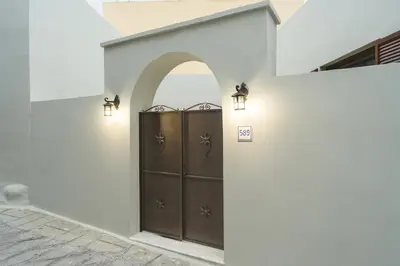 a door in a white wall with lights at Aesthisis Sensational Accommodation Archangelos in Archangelos