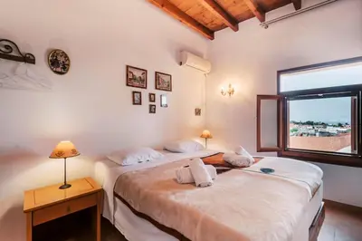 two twin beds in a room with a window at Kristinas View Studios in Rhodes Town