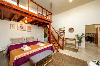 a bedroom with a large bed and a staircase at Alchadef Park Apartment in Rhodes Town